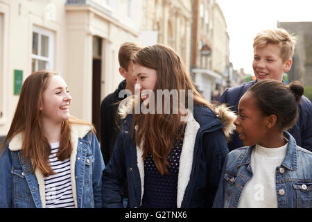 Gruppo di adolescenti a piedi lungo la strada nel contesto urbano Foto Stock