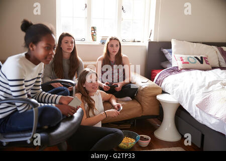 Un gruppo di ragazze adolescenti la riproduzione del video gioco in camera da letto Foto Stock