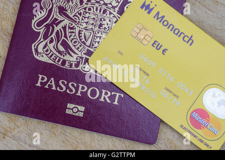 Close up di un Monarch Airlines euro prepaid mastercard con un passaporto del Regno Unito Foto Stock