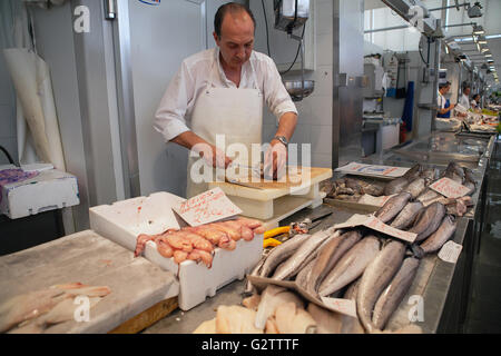 Spagna, Andalusia Cadiz, un pescivendolo di filetti di pesce al suo in stallo il Mercato Centrale. Foto Stock