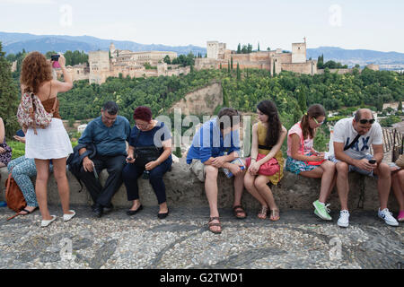 Spagna, Andalusia Granada, turisti guardano di fronte all'Alhambra dal punto di vista a la Iglesia de San Nicolas nel quartiere Albayzin. Foto Stock