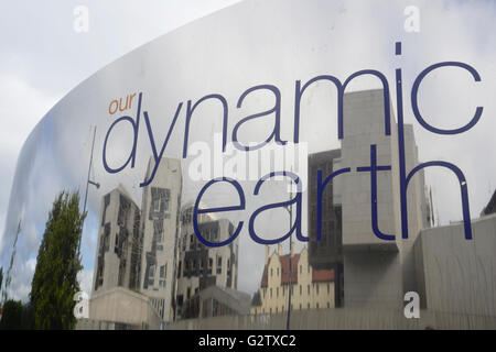 La Scozia, Edimburgo, Our Dynamic Earth, segno dello specchio con la costruzione del parlamento scozzese riflessa in esso. Foto Stock