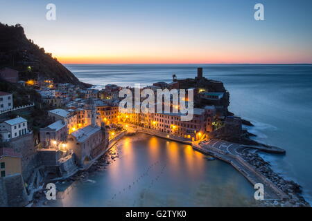 Vista notturna del tipico villaggio di Vernazza circondato dal blu del mare e le luci del parco nazionale delle cinque terre liguria italia Foto Stock