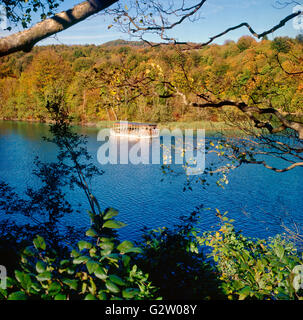 Un turista barca vela nel Parco Nazionale dei laghi di Plitvice in autunno Foto Stock