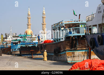 Dhawos ormeggio nel porto di Sharjah e torri della moschea Almaghfirah dietro Foto Stock