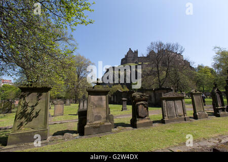 Città di Edimburgo in Scozia. Vista pittoresca di St Cuthbert chiesa parrocchiale del cimitero, con il Castello di Edimburgo in background. Foto Stock