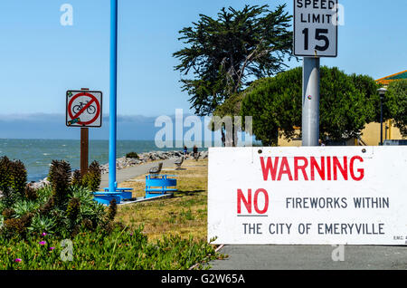 Un trio di cartelli di avvertimento su Powell Street a Emeryville in California con la nebbia di mattina di San Francisco in background. Foto Stock