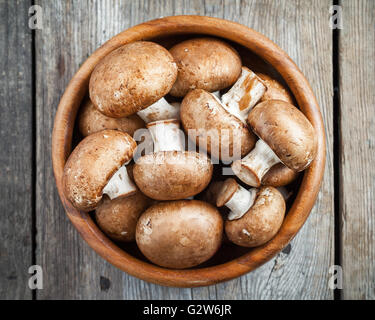 I funghi nel recipiente di legno sul tavolo. Vista dall'alto. Foto Stock