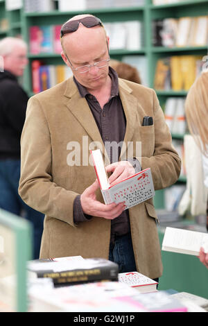 Festival di fieno, Wales, Regno Unito - Sabato 4 Giugno 2016 - un ospite al Festival che esplora i nuovi libri in vendita presso il bookshop del Festival. Foto Stock