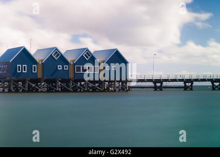 Una lunga esposizione, ancora acque oceaniche e quattro piccoli edifici blu sul Busselton Jetty, il più lungo molo in legno. Foto Stock