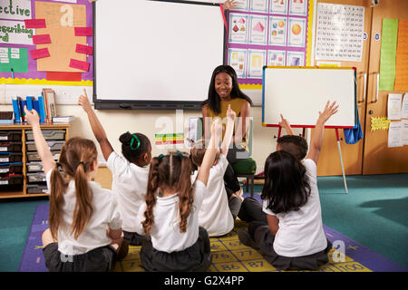 Insegnante chiede la scuola elementare alunni questione in Aula Foto Stock