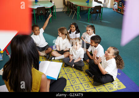 Insegnante chiede la scuola elementare alunni questione in Aula Foto Stock