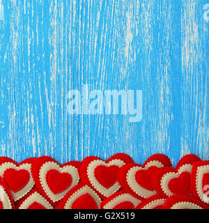 Cuori rossi su sfondo blu sullo sfondo di legno Foto Stock