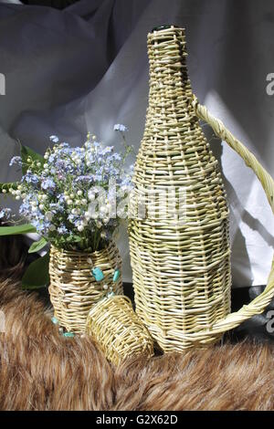 Artigianato prodotti dalla bottiglia di salice, un bicchiere, un vaso con fiori di primavera decorazione per la casa Foto Stock