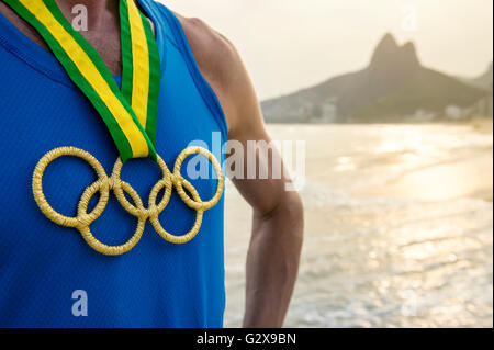 RIO DE JANEIRO - MARZO 20, 2016: atleta sta indossando gli anelli olimpici medaglia d'oro della spiaggia di Ipanema nella celebrazione dei Giochi. Foto Stock