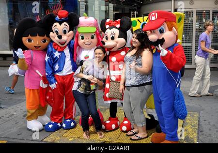 New York City: turisti con Disney Topolino e Minnie Mouse e altri personaggi di film animati in Times Square Foto Stock
