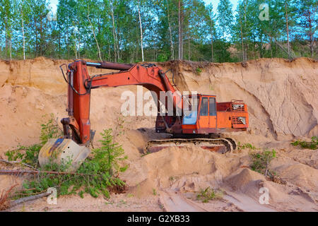 Escavatore lavorando sulle dune di sabbia in cava Foto Stock