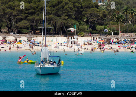 Barca a vela di fronte ad una spiaggia di sabbia fine, Cala Marcal, Mallorca, Maiorca, isole Baleari, Spagna Foto Stock