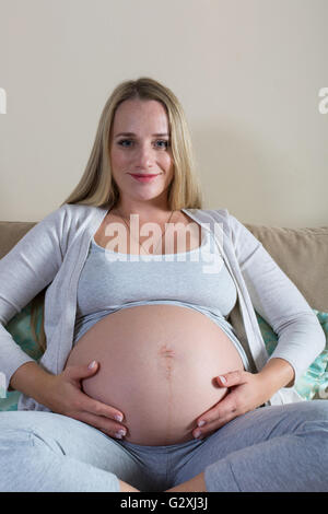 Donna incinta di accarezzare il suo ventre Foto Stock