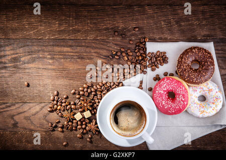 I chicchi di caffè ciambella su una tavola di legno Foto Stock