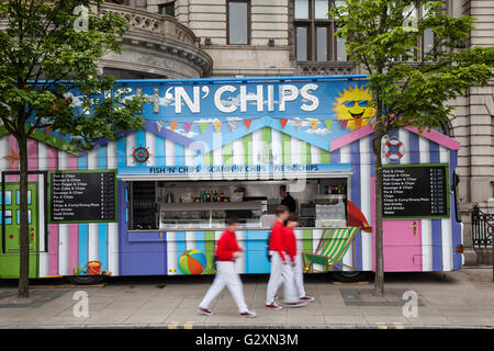 Fish n chips; Candy Stripped Seaside Fast food chippy catering trailer, cibo, take-away mobile, van trailer, catering, mangiare, fast food, pranzo, strada, trasporto, camion, urbano, servizio, snack, trasporto, affari, caffetteria, ristorante. Candy Stripe 'Fish & chip' furgone catering mobile in attesa del Cunard Queen Mary arrivo all'alba su Princes Dock, Merseyside, Regno Unito Foto Stock