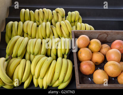 Banane e pompelmo sul display in un mercato Foto Stock