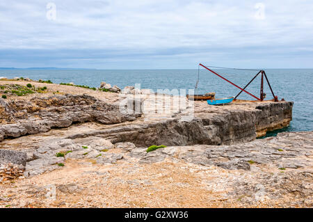 La gru rosso che è parte dell'ora in disuso Portland Bill stone banchina di carico sul ciglio della scogliera a Portland a sud del punto Foto Stock