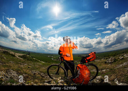 Giovane Maschio ciclista parlando al cellulare Foto Stock
