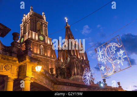 Le guglie della Parroquia de San Miguel Arcangel chiesa e Iglesias de San Rafael chiesa illuminati al crepuscolo con decorazioni di Natale in San Miguel De Allende, Messico. Foto Stock