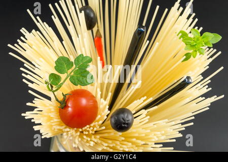 Materie spaghetti con pomodoro e olive poste in forma a spirale pronti per la cottura Foto Stock