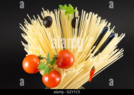 Materie spaghetti con pomodoro e olive poste in forma a spirale pronti per la cottura Foto Stock