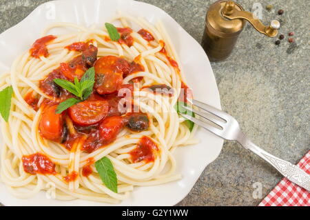 Spaghetti servita con ketchup, formaggio, verdure e prezzemolo. Foto Stock