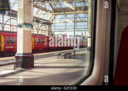 Stazione Waterloo di Londra platform osservata attraverso una finestra del treno Foto Stock