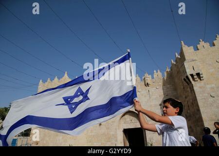 Gerusalemme. 5 Giugno, 2016. Un ragazzo israeliano sventola una bandiera nazionale di Israele durante un mese di marzo per contrassegnare Israele il 1967 cattura di Gerusalemme est alla porta di Damasco a Gerusalemme la città vecchia, il 5 giugno 2016. Decine di migliaia di israeliani hanno marciato Domenica a Gerusalemme palestinese prevalentemente la città vecchia in mezzo alle alte tensioni per contrassegnare Israele il 1967 cattura di Gerusalemme Est. Credito: Muammar Awad/Xinhua/Alamy Live News Foto Stock