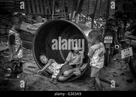 Thailandia povertà. Bambini che giocano tra le macerie in una backstreet tailandese. Thailandia S. E. Asia. Bambini slum. Fotografia in bianco e nero Foto Stock