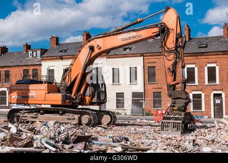 Un escavatore da demolizione su un interno sito della città dove le case vengono demoliti. Foto Stock