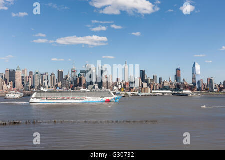 La nave di crociera norvegese teste di disinnesto a sud sul fiume Hudson oltre la metà-città skyline di New York City. Foto Stock