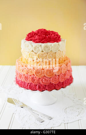 Due tier torta nuziale con crema di burro turbinii di rose Foto Stock