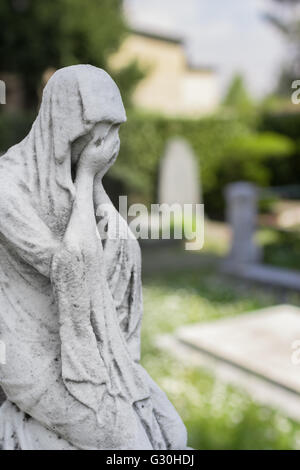 Statua di una donna disperata. Sfocati sfondo sfocato. Foto Stock