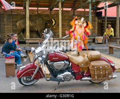 Una fine del modello di moto Indian con un nativo americano ballerino in prestazioni, con gli spettatori che guarda. Foto Stock