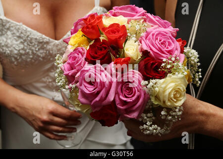 Scena di nozze contenente un dettaglio delle spose bouquet di fiori che include il Rosa Rose e rose rosse Foto Stock