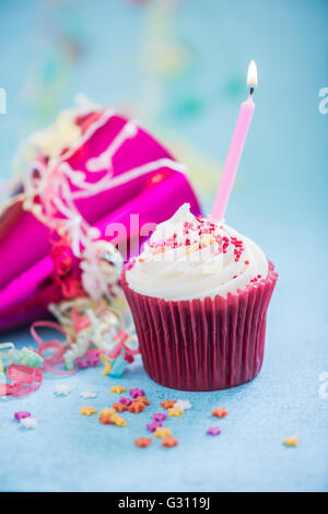 Festeggia il compleanno con cupcake e candela su sfondo blu Foto Stock