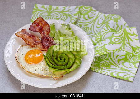 Uova fritte, pancetta e avocado è salito per la prima colazione Foto Stock