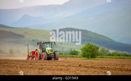 Aratri trattore un campo in primavera. Foto Stock