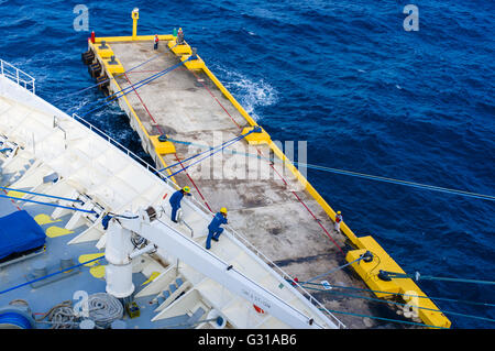 I membri dell'equipaggio tirare le funi che fissano la nave di crociera visione del mare al molo a Costa Maya, Messico Foto Stock