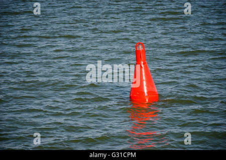 Galleggiante rosso boa di navigazione sulle acque blu Foto Stock