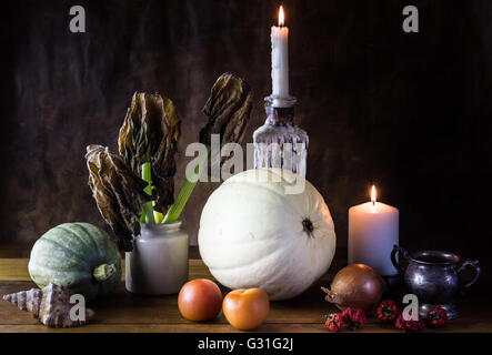 Vanitas stile di vita ancora con zucche, verdure e candele accese isolate su tavola di legno Foto Stock