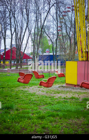 Molla di vuoto il vecchio parco di divertimenti, catena giostra swing attende i visitatori, filtrato per effetto rétro Foto Stock