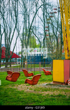 Molla di vuoto il vecchio parco di divertimenti, catena giostra swing attende i visitatori, filtrato per effetto rétro Foto Stock