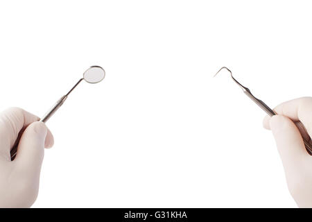 Specchio di dentista e sonda in mani Foto Stock